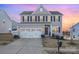 Two-story house with gray siding, white trim, and a three-car garage at 7067 Waterwheel Sw St, Concord, NC 28025