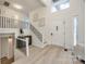 Bright and airy entryway with modern staircase and light wood floors at 7137 Windyrush Rd, Charlotte, NC 28226