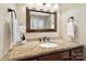 Well-lit bathroom featuring granite countertop, dark wood cabinets, and updated lighting at 761 Summerwood Dr, Rock Hill, SC 29732