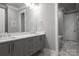 Double vanity bathroom with grey cabinets and quartz countertop at 7908 Rea View Ct, Charlotte, NC 28226