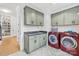 Laundry room with green cabinets, washer, dryer and built-in sink at 832 Heather Ln, Charlotte, NC 28209