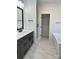 Bathroom featuring dual vanities, marble-look tile flooring, a separate shower, and a soaking tub at 8823 Wingard Rd, Waxhaw, NC 28173