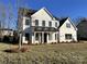 Beautiful two-story home featuring white board and batten siding, black windows, and a covered front porch at 8823 Wingard Rd, Waxhaw, NC 28173