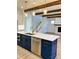 Kitchen island boasts blue cabinets, stainless steel appliances, quartz countertop, and pendant lighting at 8823 Wingard Rd, Waxhaw, NC 28173