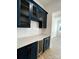 Close-up of a wet bar with a wine cooler and herringbone tile backsplash at 8823 Wingard Rd, Waxhaw, NC 28173