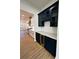 Stylish wet bar featuring navy cabinets, wine cooler, white countertops and herringbone backsplash at 8823 Wingard Rd, Waxhaw, NC 28173