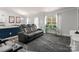 Living room with dark gray reclining sofas, a large TV, and a decorative rug at 1259 Amberlight Cir, Salisbury, NC 28144