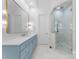 Elegant bathroom featuring a blue vanity, large mirror, and a glass shower at 13505 Evening Primrose Dr, Davidson, NC 28036