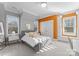 Bright bedroom with gray upholstered bed, window seat, and orange accent wall at 13505 Evening Primrose Dr, Davidson, NC 28036