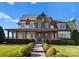 Two story home with stone accents, large front porch, and manicured landscaping at 13505 Evening Primrose Dr, Davidson, NC 28036