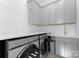 Modern laundry room with gray cabinets, quartz countertops, and new Samsung appliances at 13505 Evening Primrose Dr, Davidson, NC 28036