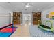 Playroom with built-in bookshelves, mini trampoline, and access to upper level at 13505 Evening Primrose Dr, Davidson, NC 28036