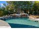 Inviting pool with a beautiful stone waterfall feature at 13505 Evening Primrose Dr, Davidson, NC 28036