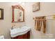 Stylish powder room with a pedestal sink and decorative mirror at 13924 Island Dr, Huntersville, NC 28078