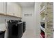 Bright laundry room with washer, dryer,cabinets, and shelving at 14206 Morningate St, Huntersville, NC 28078