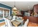 Dining room boasts hardwood floors, seating for six, stylish light fixture and open view of kitchen and living room at 1467 Kensington Park Ct, Hickory, NC 28602