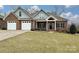 Charming brick home featuring a three-car garage and well-manicured front lawn at 1467 Kensington Park Ct, Hickory, NC 28602