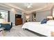 A well-lit main bedroom featuring a ceiling fan, tray ceilings, and an elegant dresser with a television at 1467 Kensington Park Ct, Hickory, NC 28602