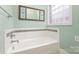 Bathroom with a bathtub, tile border, and decorative mirror at 1610 Elkhart Cir, Gastonia, NC 28054