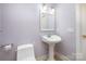 Small bathroom with pedestal sink, toilet and mirror at 1610 Elkhart Cir, Gastonia, NC 28054