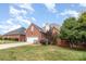 Landscaped lawn and brick home with a two-car garage at 1610 Elkhart Cir, Gastonia, NC 28054