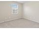 Well-lit bedroom with neutral walls and carpet, featuring a window with blinds at 1620 #G Arlyn Cir, Charlotte, NC 28213