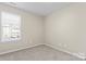 Bright bedroom with neutral walls and carpet, featuring a window with blinds at 1620 #G Arlyn Cir, Charlotte, NC 28213