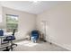 Sunlit bedroom featuring a blue accent chair, desk with view, and comfortable carpet flooring at 1620 #G Arlyn Cir # G, Charlotte, NC 28213