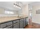 A view of the kitchen featuring gray cabinets, granite counters, and hardwood floors at 1620 #G Arlyn Cir # G, Charlotte, NC 28213