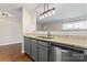 This is a kitchen with gray cabinets, granite counters, hardwood floors, and stainless steel appliances at 1620 #G Arlyn Cir # G, Charlotte, NC 28213