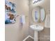 Simple pedestal sink, round mirror, and neutral color scheme at 206 River Clay Rd, Fort Mill, SC 29708