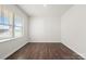 Simple bedroom with dark hardwood floors and a window with blinds at 221 Wildflower Dr, Locust, NC 28097