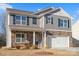 Two-story house with gray siding, stone accents, and a two-car garage at 221 Wildflower Dr, Locust, NC 28097