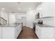 Modern kitchen with white cabinets, granite island, and hardwood floors at 221 Wildflower Dr, Locust, NC 28097