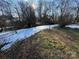 Large backyard partially covered in snow, sunny day at 2244 9Th Ne Ave, Hickory, NC 28601