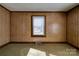 Bright bedroom with wood paneling, window, and neutral carpet at 304 Edel St, Kings Mountain, NC 28086