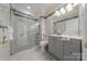 Modern bathroom with gray vanity, tiled shower, and marble flooring at 4225 Nathaniel Glen Ct, Matthews, NC 28105