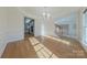 Bright dining room with hardwood floors and chandelier, open to kitchen and stairs at 4225 Nathaniel Glen Ct, Matthews, NC 28105