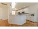 White kitchen with granite countertops, stainless steel appliances, and hardwood floors at 4225 Nathaniel Glen Ct, Matthews, NC 28105