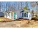 Charming single-story home featuring a bright turquoise door, white siding, and well-maintained front yard at 4901 Smokehollow Rd, Charlotte, NC 28227