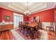 Formal dining room with hardwood floors, red walls, and a chandelier at 5218 Shadow Pond Ln, Charlotte, NC 28226