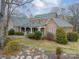 Stone house with a large front porch and landscaped yard at 5218 Shadow Pond Ln, Charlotte, NC 28226