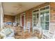 Spacious front porch with stone flooring and white wicker furniture at 5218 Shadow Pond Ln, Charlotte, NC 28226