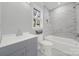 Updated bathroom with gray vanity, white bathtub, and marble tile at 624 Gaywood Dr, Charlotte, NC 28273