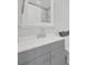 Modern gray bathroom vanity with white countertop, silver faucet, and a mirror at 624 Gaywood Dr, Charlotte, NC 28273