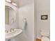 Small half bathroom with pedestal sink and round mirror at 8839 Blooming Arbor St, Huntersville, NC 28078