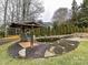 Serene backyard pond with a wooden gazebo at 8839 Blooming Arbor St, Huntersville, NC 28078