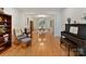 Living room with hardwood floors, piano, and view into dining area at 8839 Blooming Arbor St, Huntersville, NC 28078