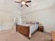 Main bedroom with a large bed, ceiling fan, and access to the en-suite bathroom at 8839 Blooming Arbor St, Huntersville, NC 28078