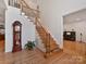 Grand staircase with wooden railing and a grandfather clock in the foyer at 8839 Blooming Arbor St, Huntersville, NC 28078